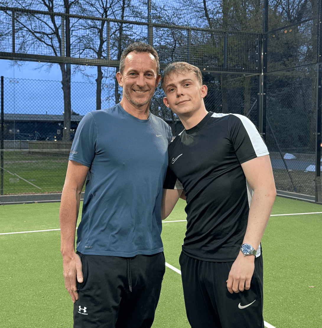 A Father and Son on a green padel tennis court