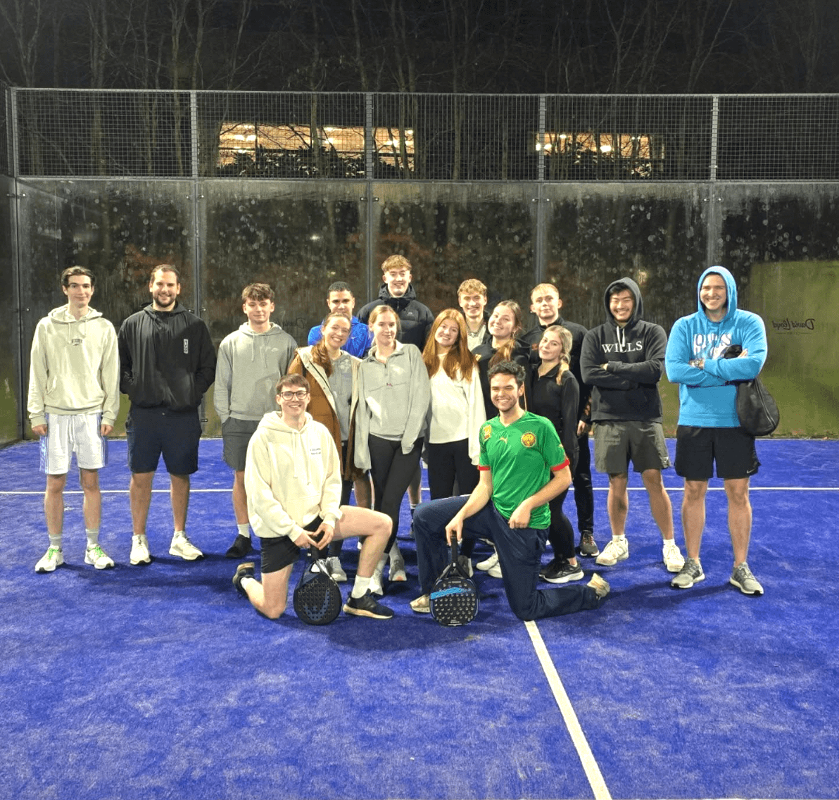 A photo of all of the members of the University of York padel society on a blue padel court
