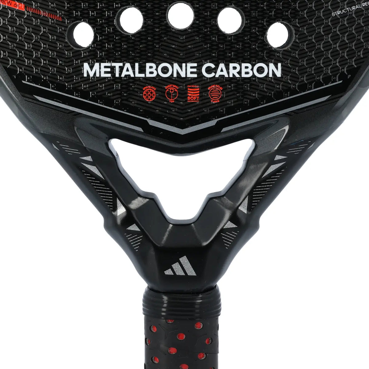 A close-up of a black Adidas Metalbone 2026 padel racket with orange detailing on a white background.