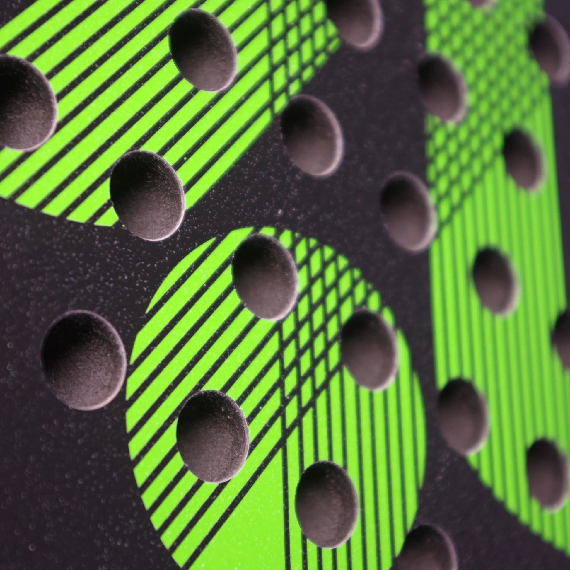 Close up of a black and green Karakal padel tennis racket face.