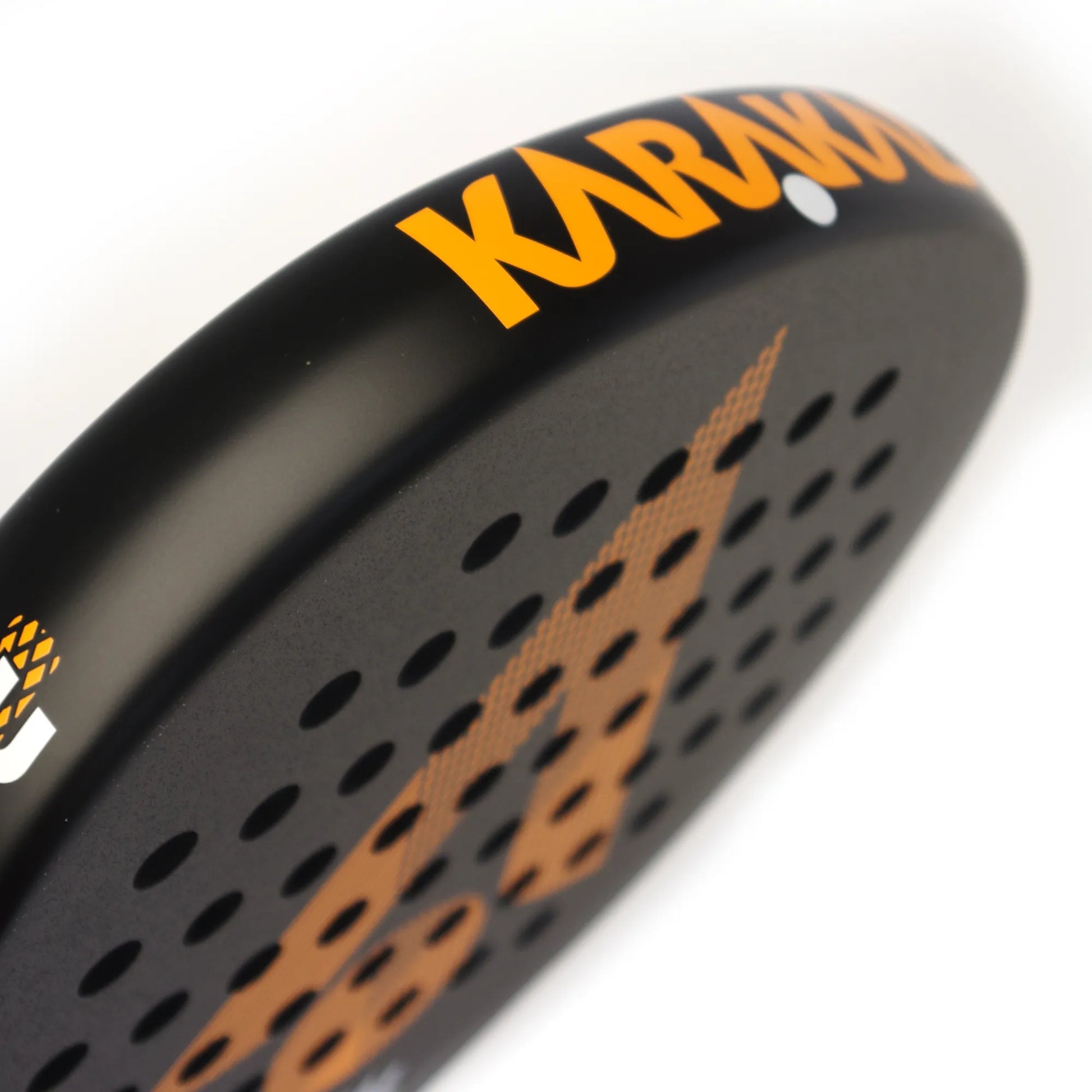 Close up of the top of a black and orange Karakal padel tennis racket on a white background.