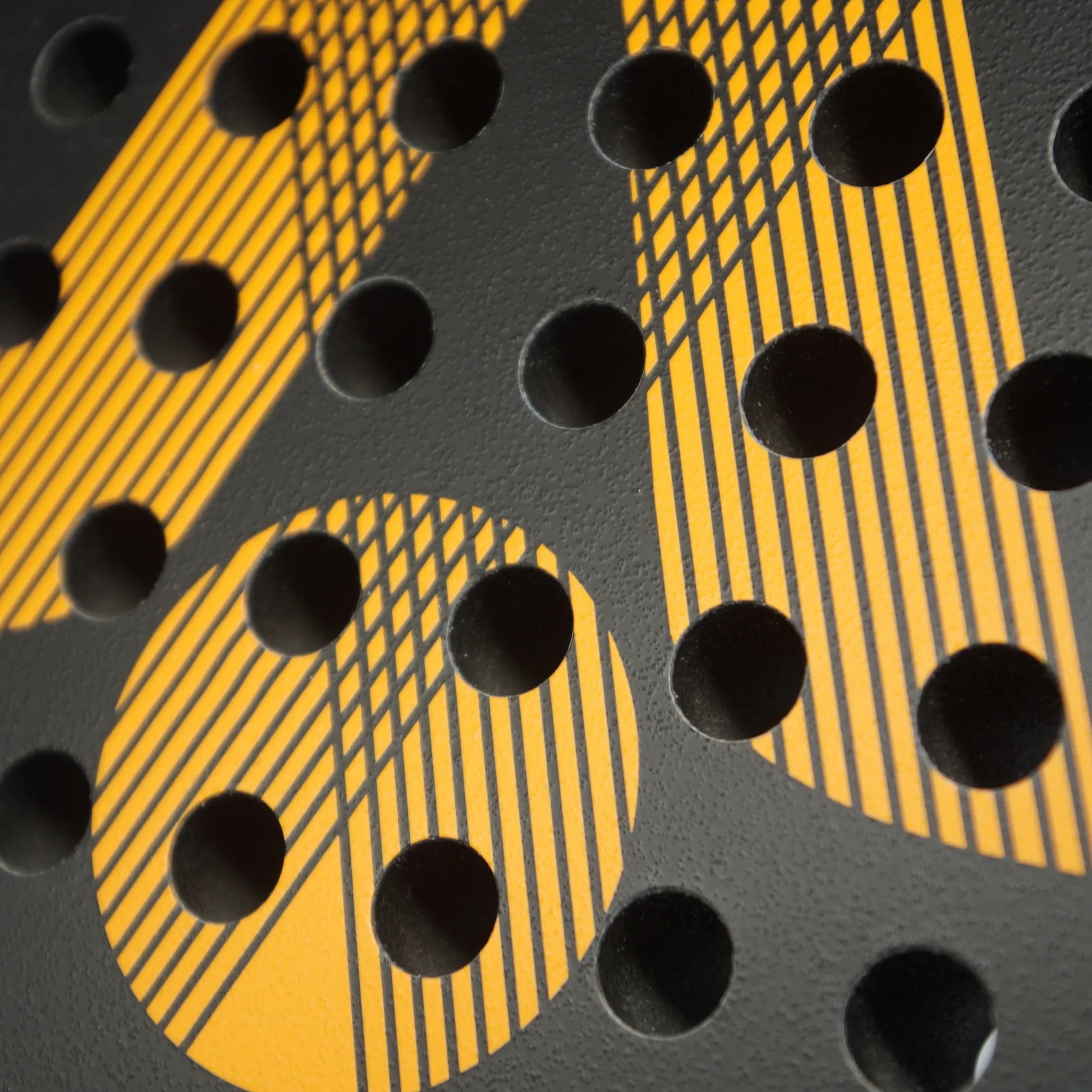 Close up of a black and orange Karakal padel tennis racket face.
