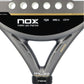 Close-up of a grey and black Nox padel racket on a white background.