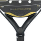 A close up of a black and gold Nox Ultimate padel racket on a white background.