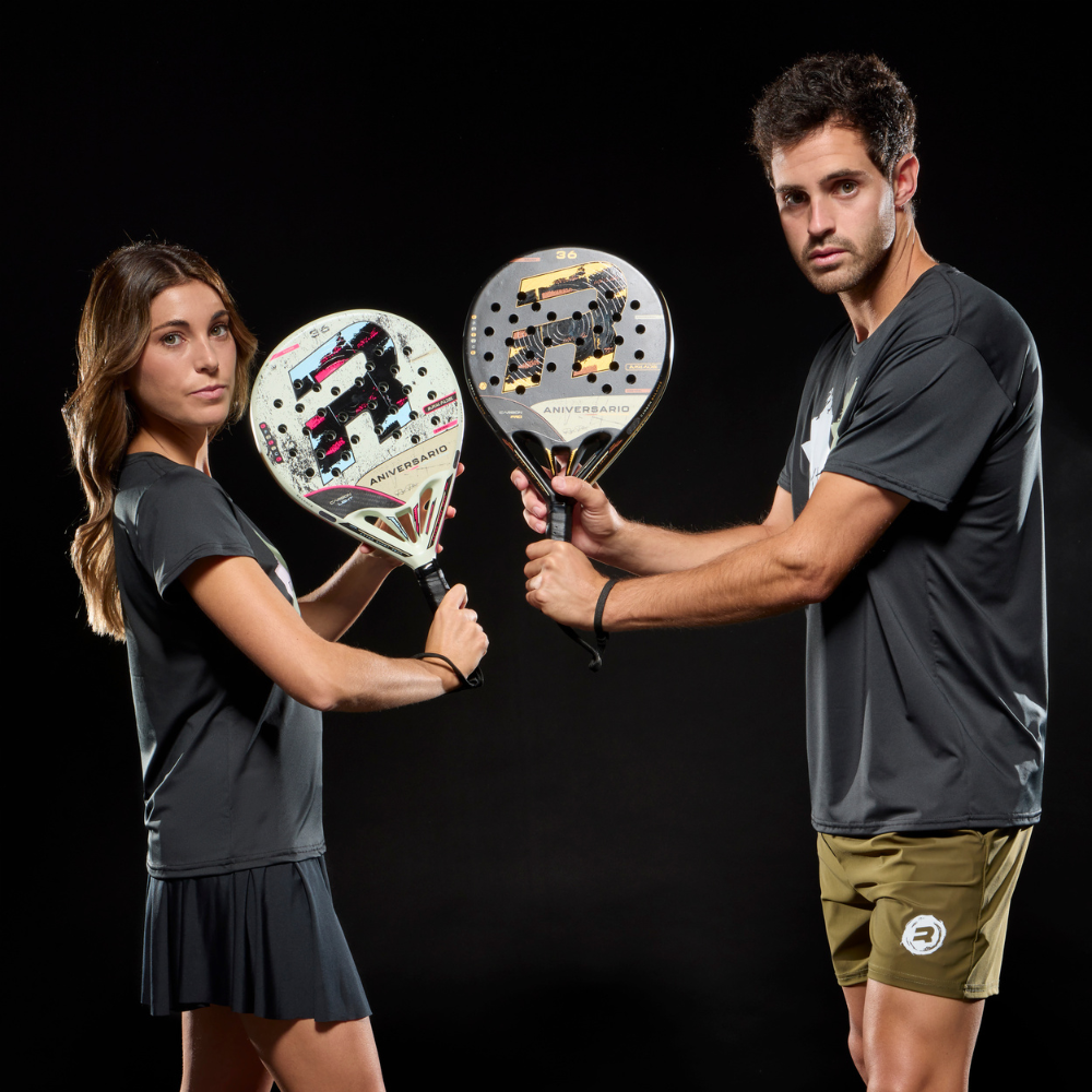 A man and a woman holding the 2026 Anniversario range of Royal Padel padel rackets on a black background.