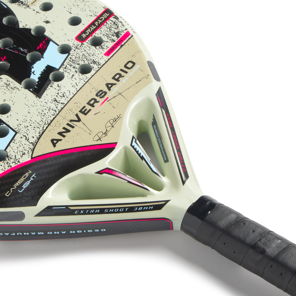 Close up of a cream Royal Padel Anniversario Light padel racket with black and pink branding on a white background.