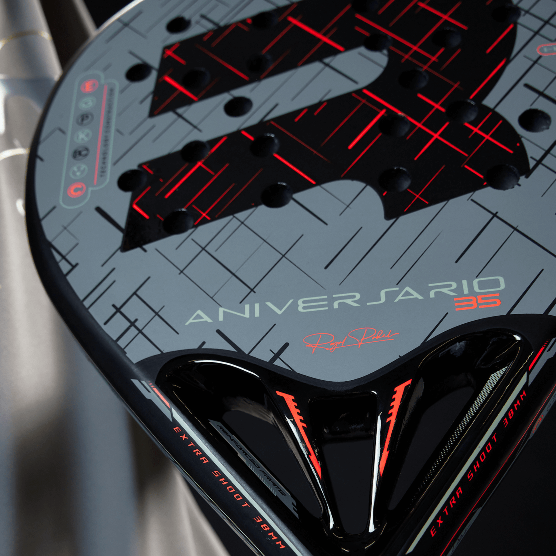 Close-up of a padel tennis racket with 'Aniversario' branding and red accents.
