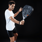 Man holding a Royal Padel M27 R ace black and gray racket against a black background