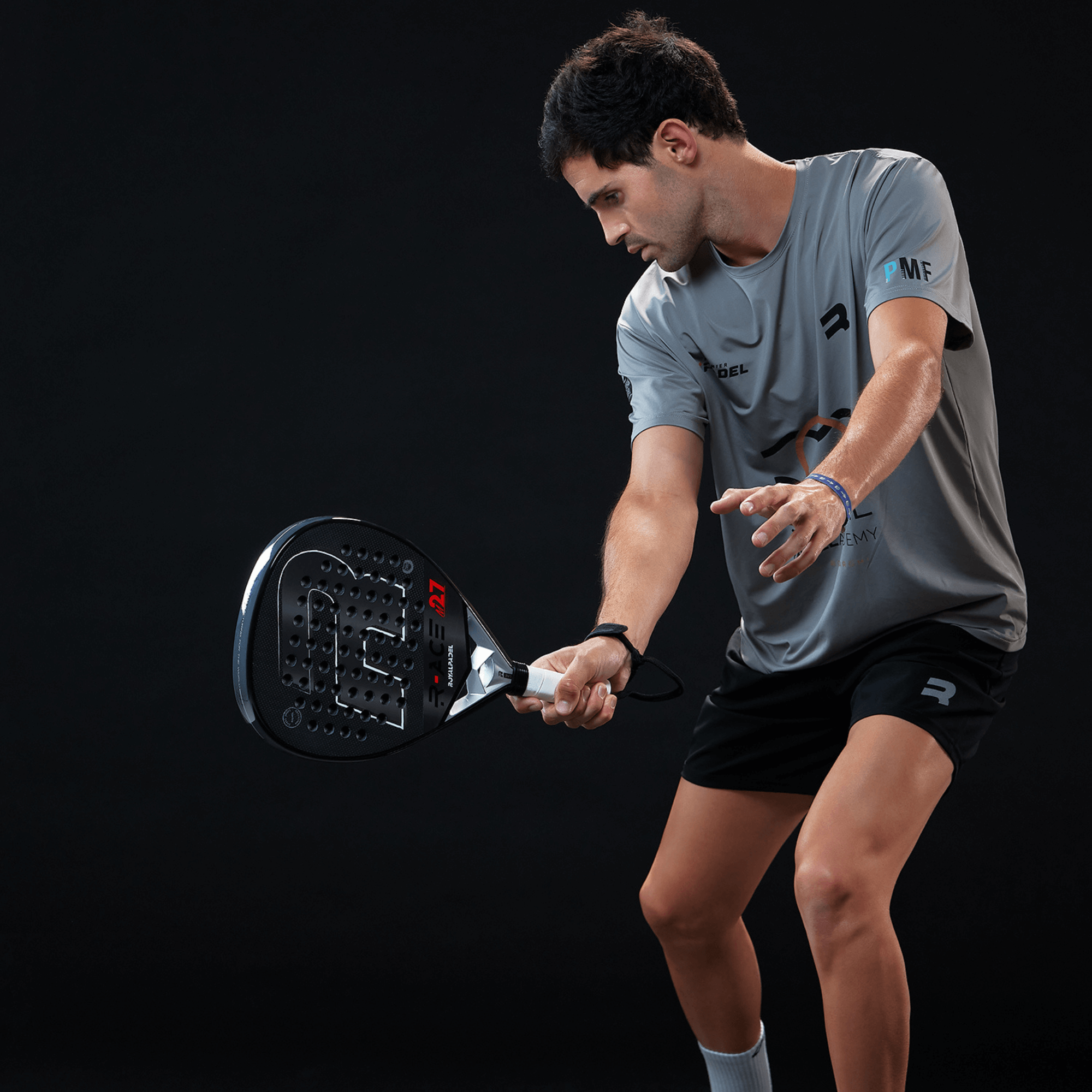 Man playing padel tennis in sports clothing with a Royal Padel racket.